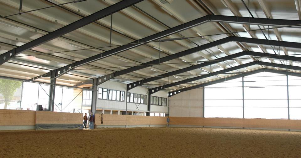 Reithalle 60 x 30 m der Reitsportanlage Haldau von innen, heller Sandboden unter der Stahlträger-Decke